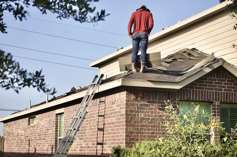 Professional roofer working on a residential roof in Southeast Warren